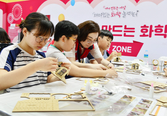 8일 충북 청주 오창공장 인근 청원초등학교 학생들이 LG화학의 '재미있는 화학 놀이터' 행사에 참여해 생활 속 편광현상을 살펴보기 위한 편광필름 실험을 하고 있다.  LG화학 제공